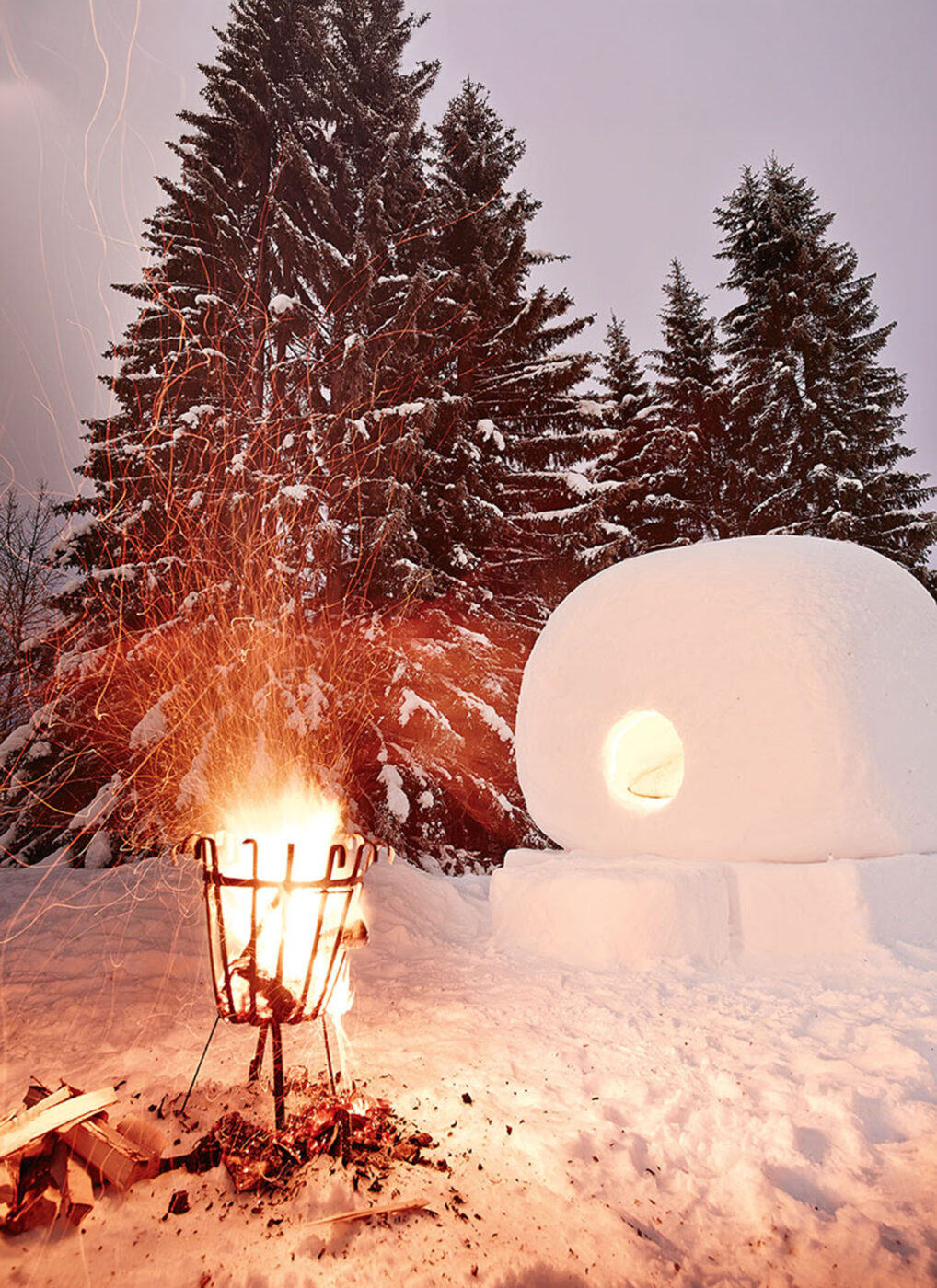 A small fire for warmth, next to a giant snowball.