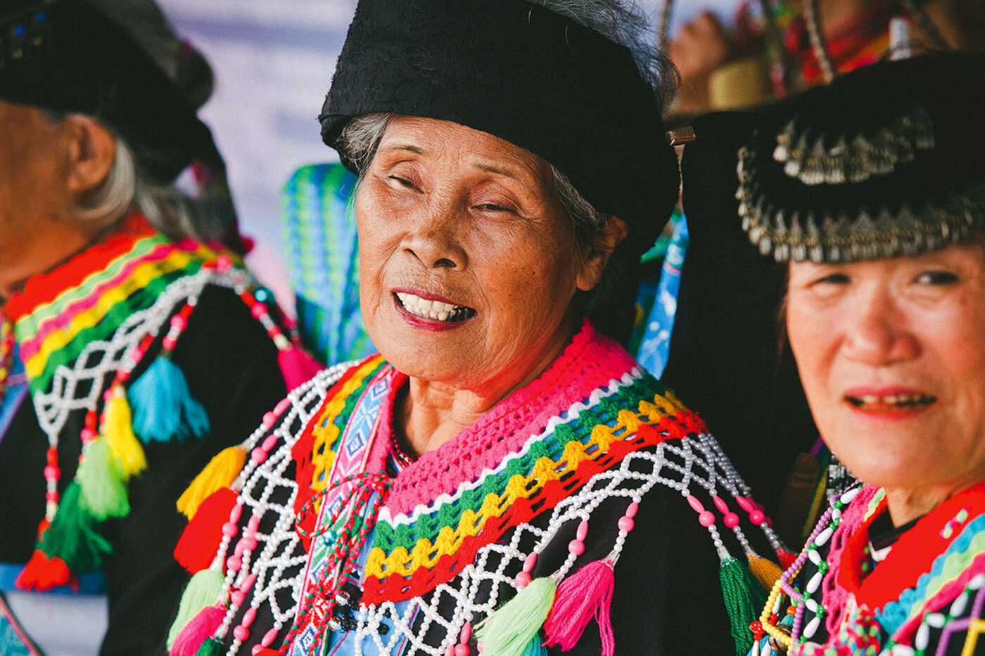 Three ladies, in rainbow knitwear. Traditional clothing.
