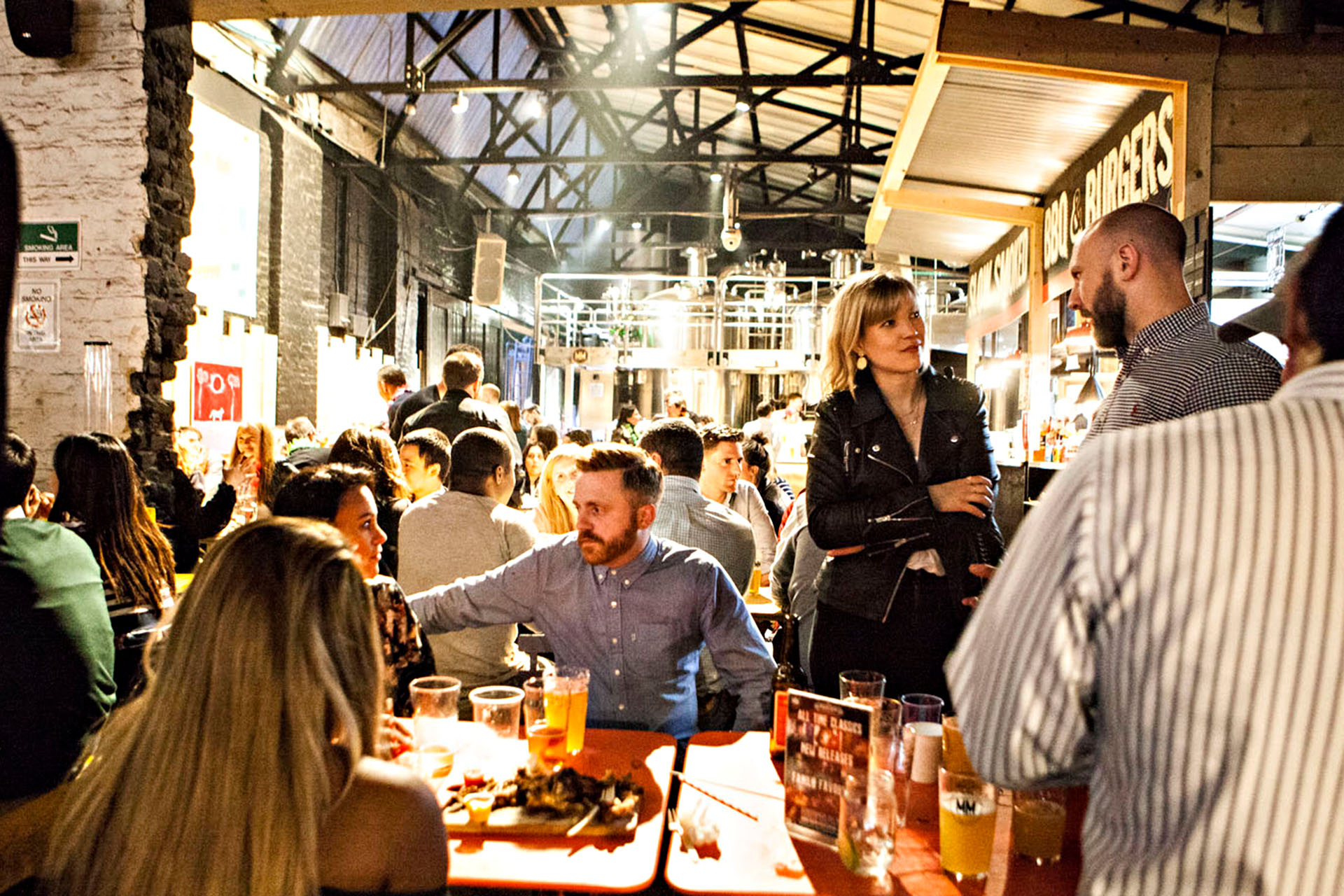 A packed restaurant with industrial decor.