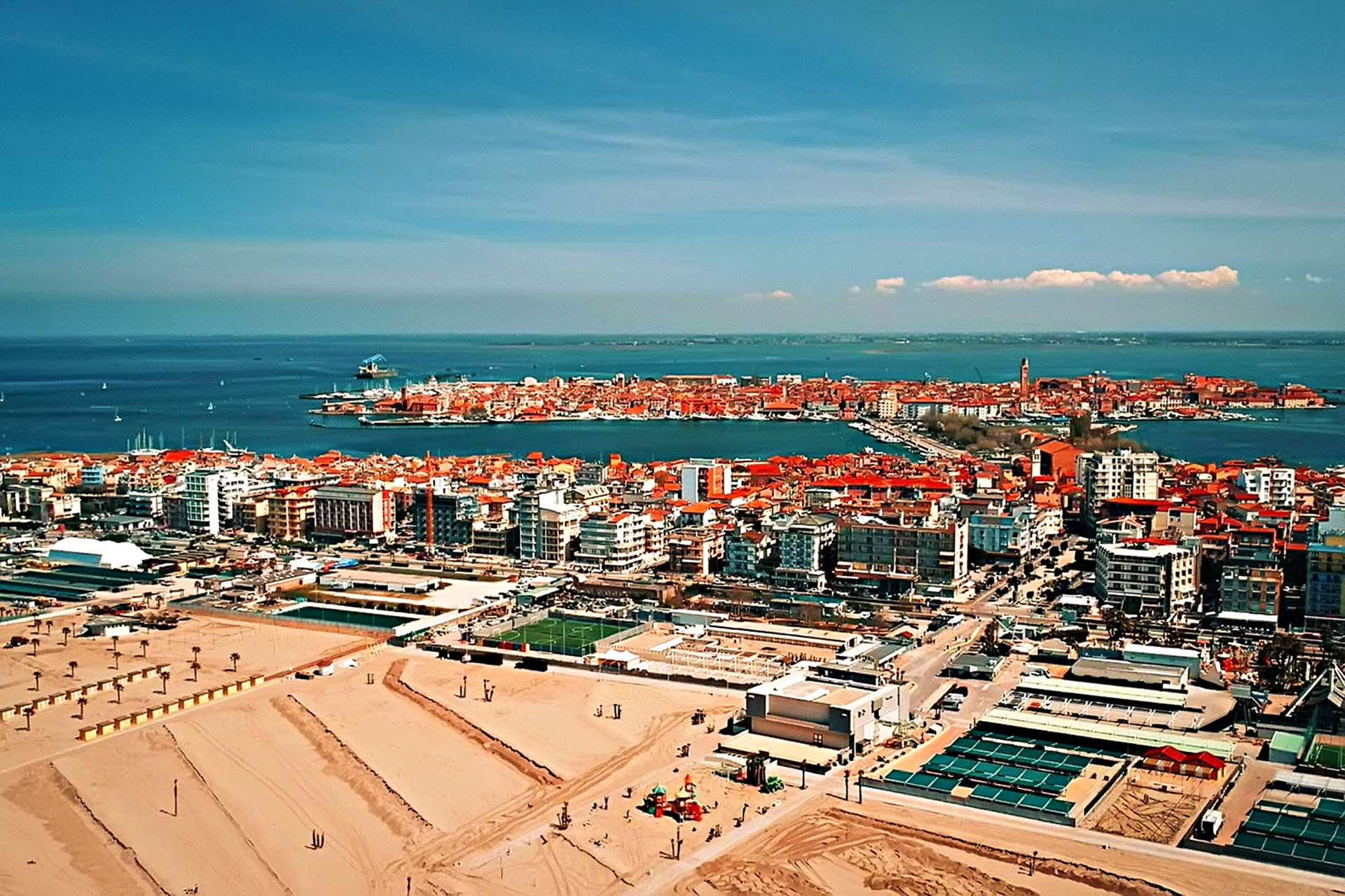 A big city with red roofs on the water.