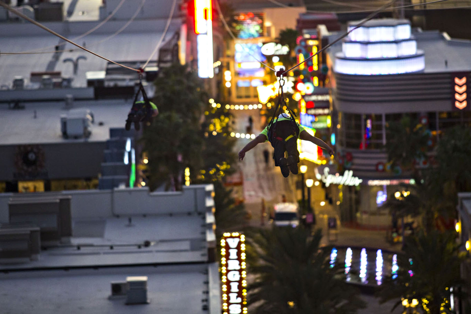 A person zip-lining over the busy vegas streets.