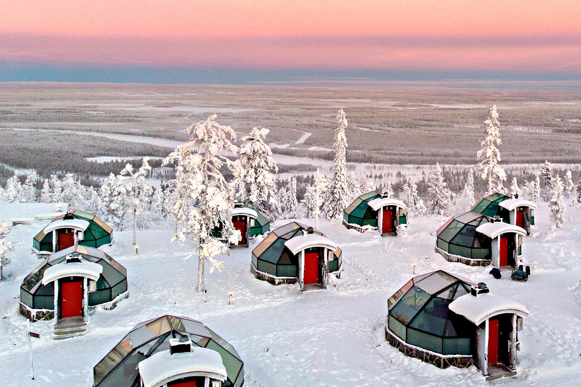 9 Igloos in the snow at sunset.