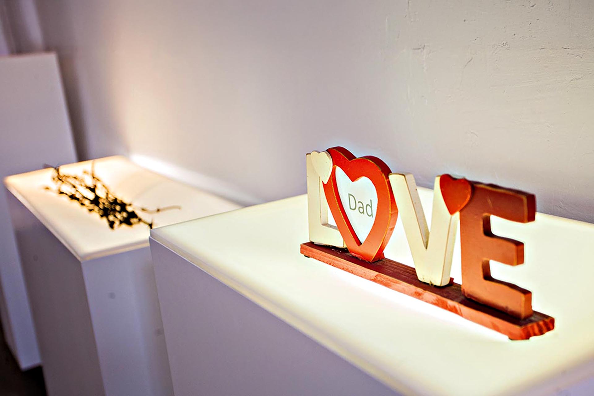 A museum display of a sign that reads 'LOVE' with the word 'Dad' inside the O.