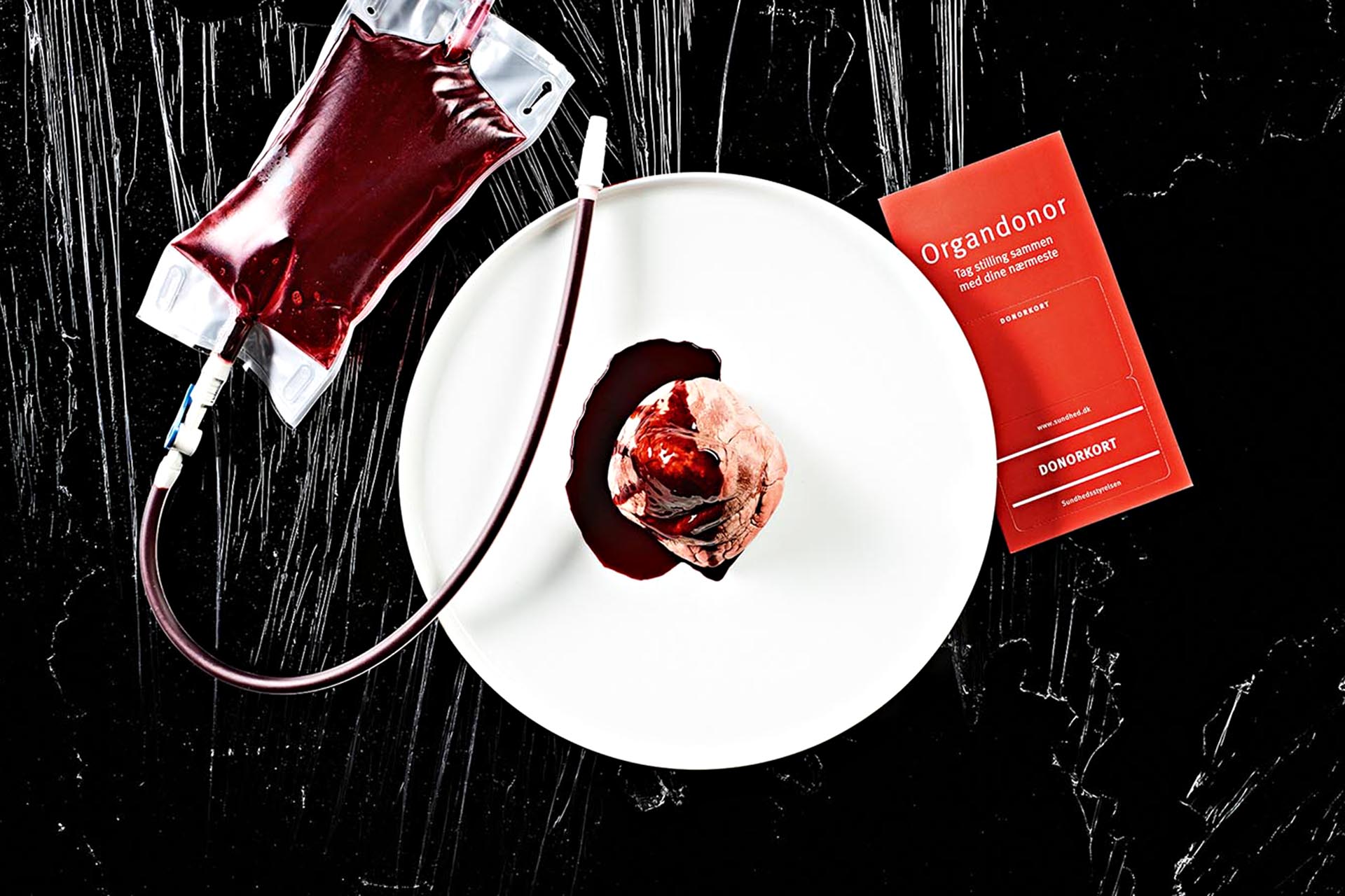 A food item covered in fake blood. Next to it, a fake IV patch with fake blood all through it. On the other side, a red card reading 'Organdonor'
