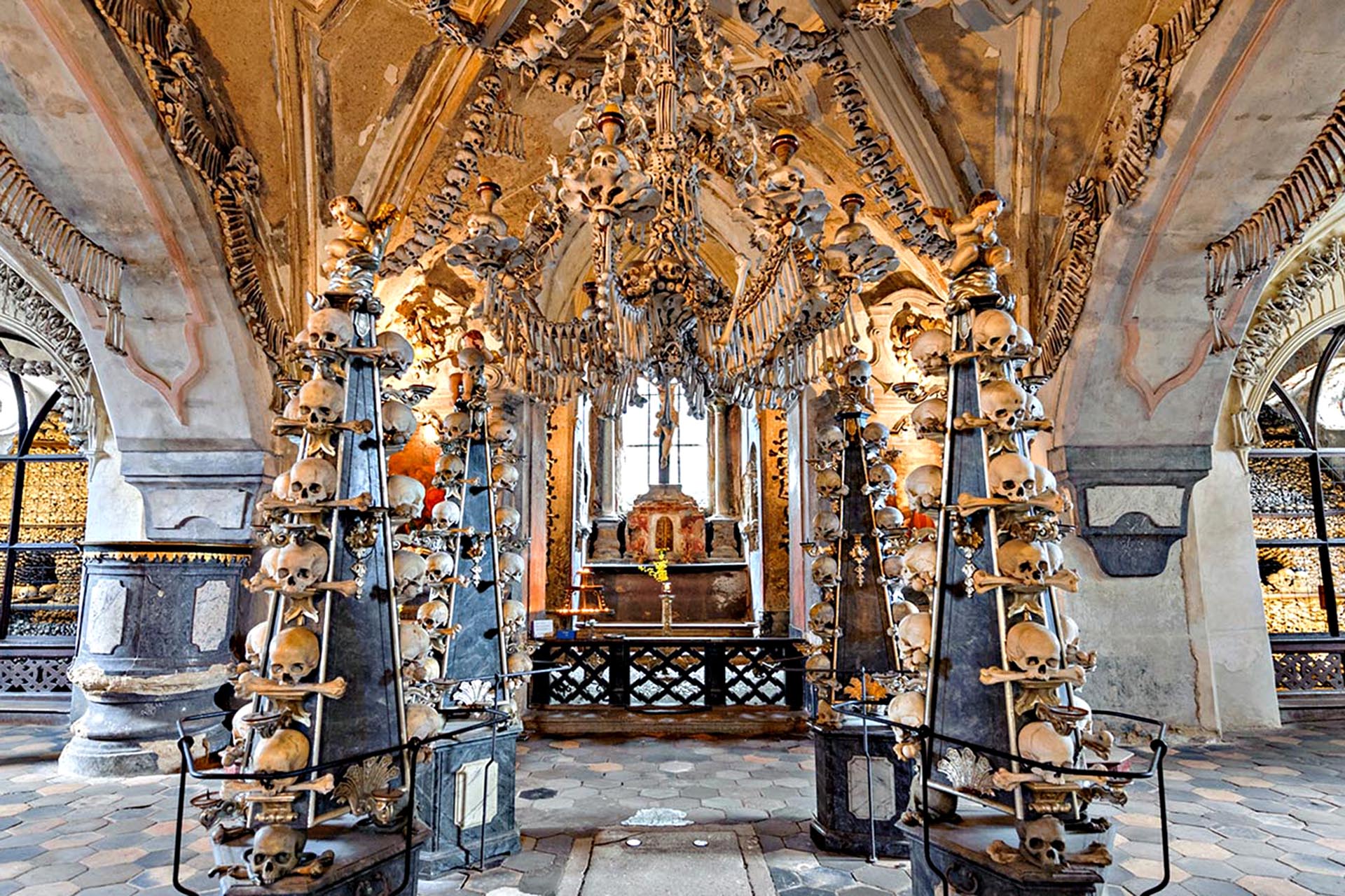 The inside of a church, with pillars of skulls stacked on-top of one another.