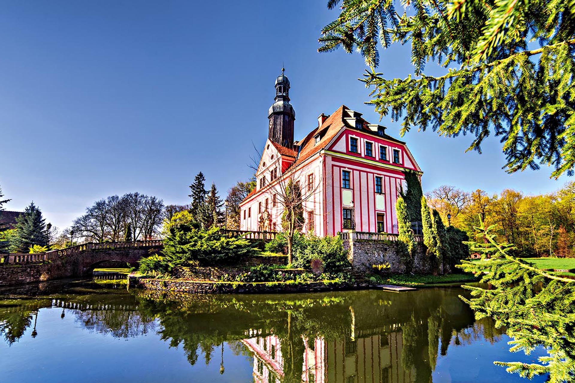 A pink castle with a moat around it.