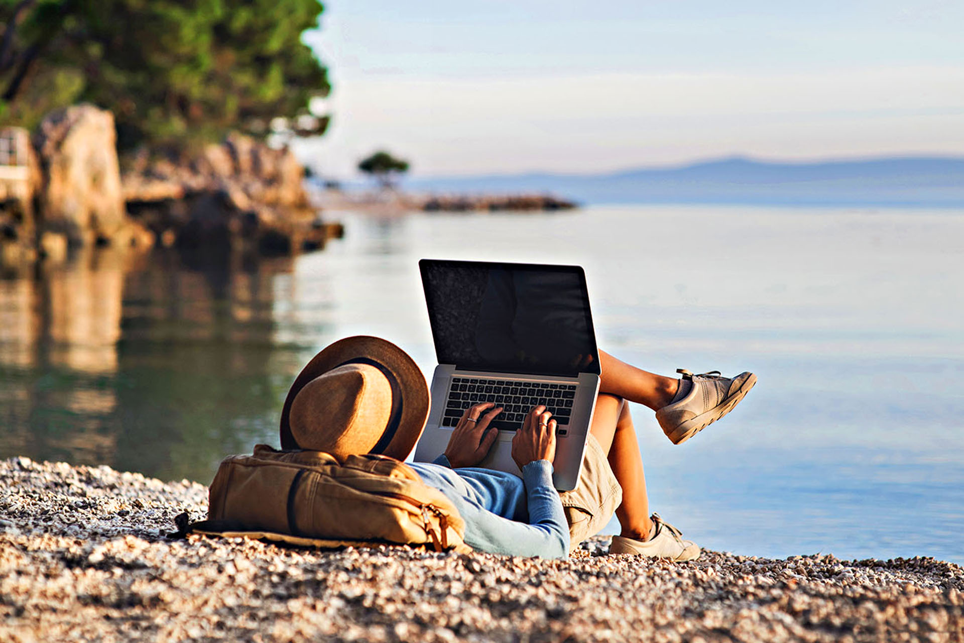 Somebody working on their Macbook at the beach.