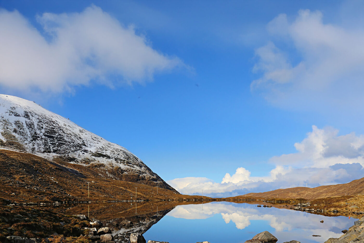 A landscape with a great lake that is so reflective it doesn't look like water.