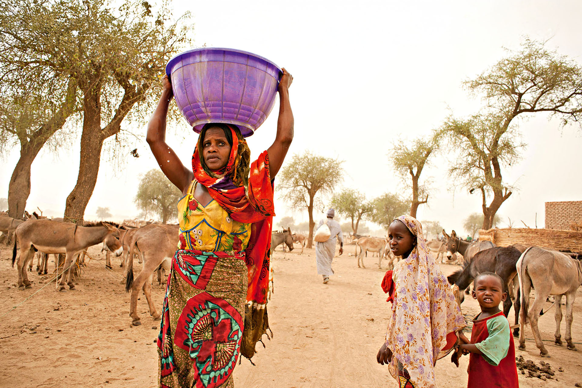 Gula woman with freshly drawn water from well. These people are Magreb Arab descendants originally from Sudan. Precious water is drawn from a communal well each day by women and children in Kashkasha village near Zakouma National Park, Chad 2010