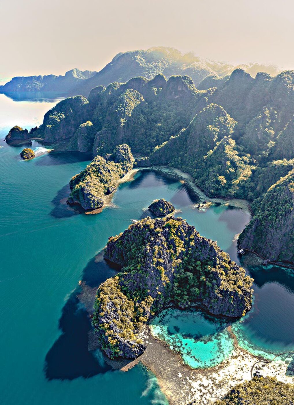 An aerial view of a large, blue lake that wraps around rock formations.