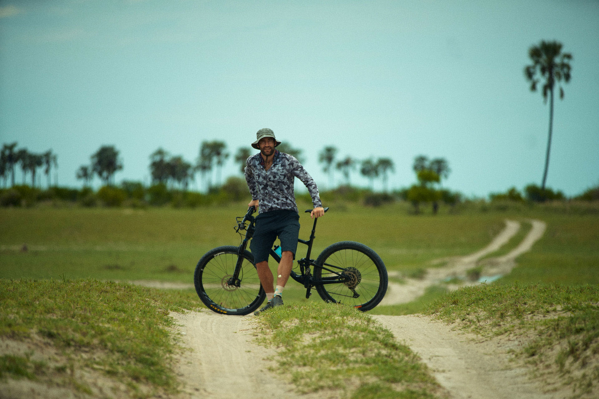 Cyclist riding through the Kalahari on a Botswana safari.