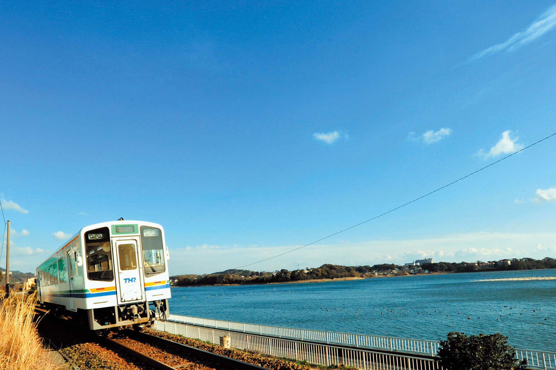 Local train travelling beside Lake Hamana in Hamamatsu.
