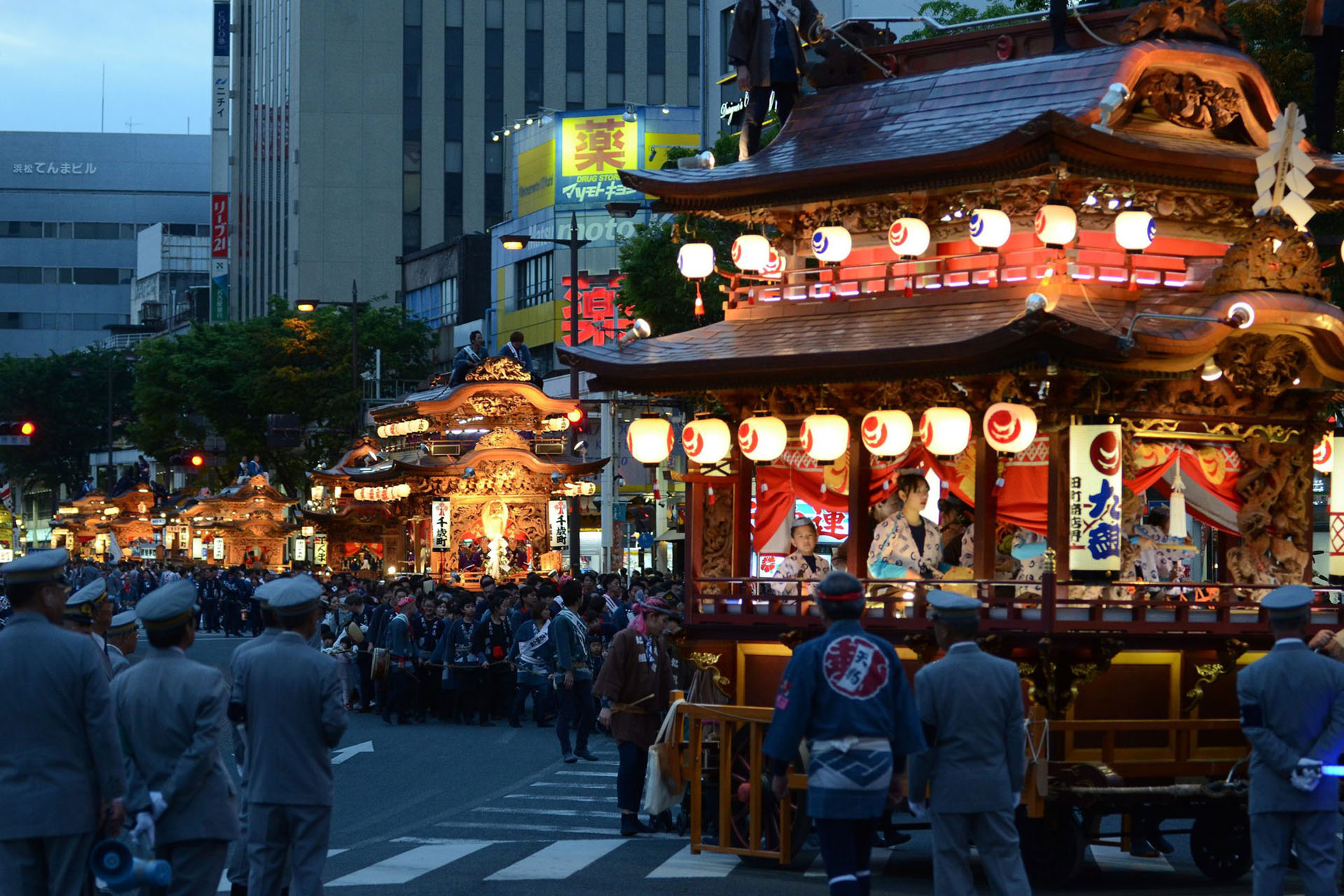 Festival floats illuminated at night during a Hamamatsu festival.