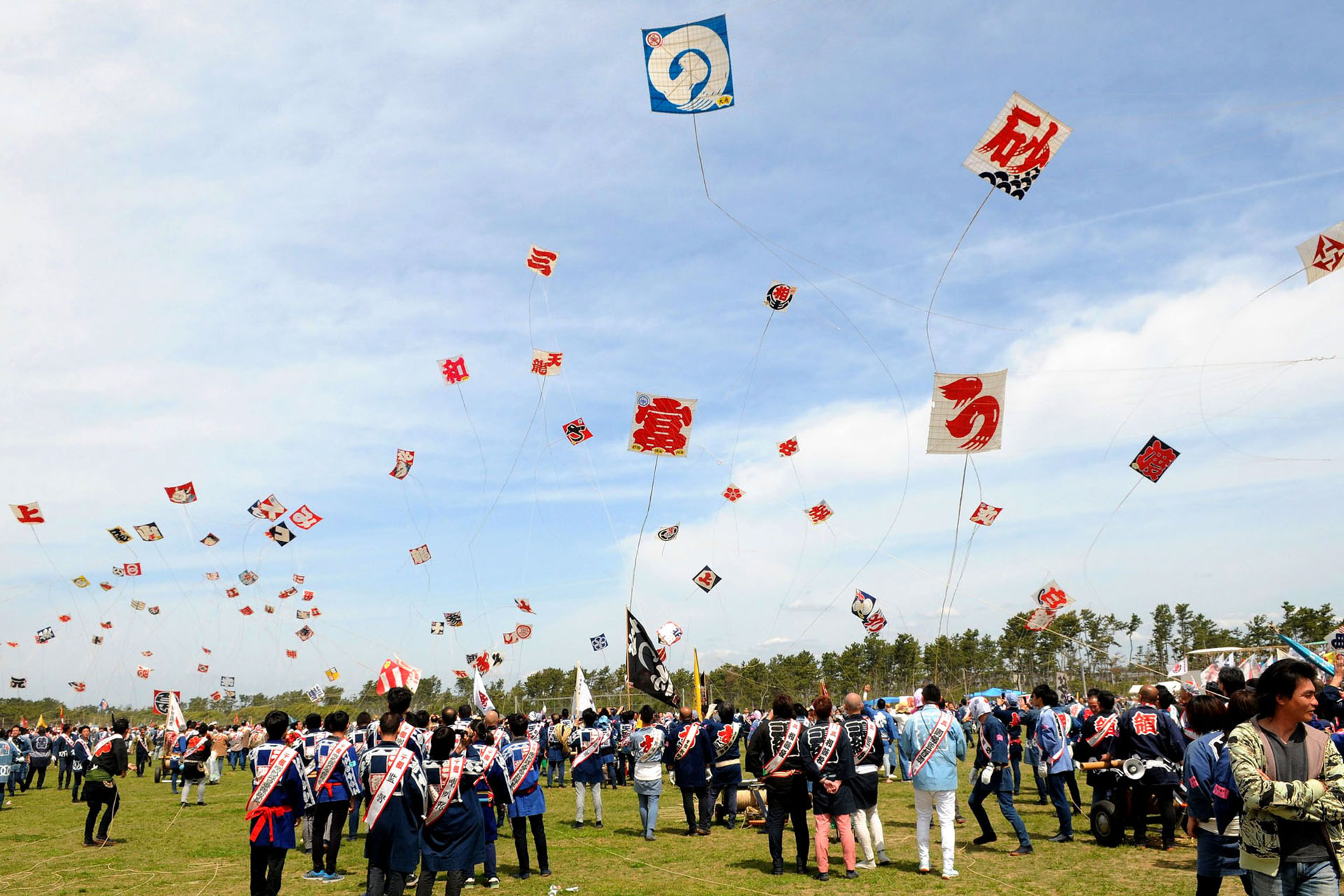 Kites flying above crowds at the Hamamatsu Kite Festival.