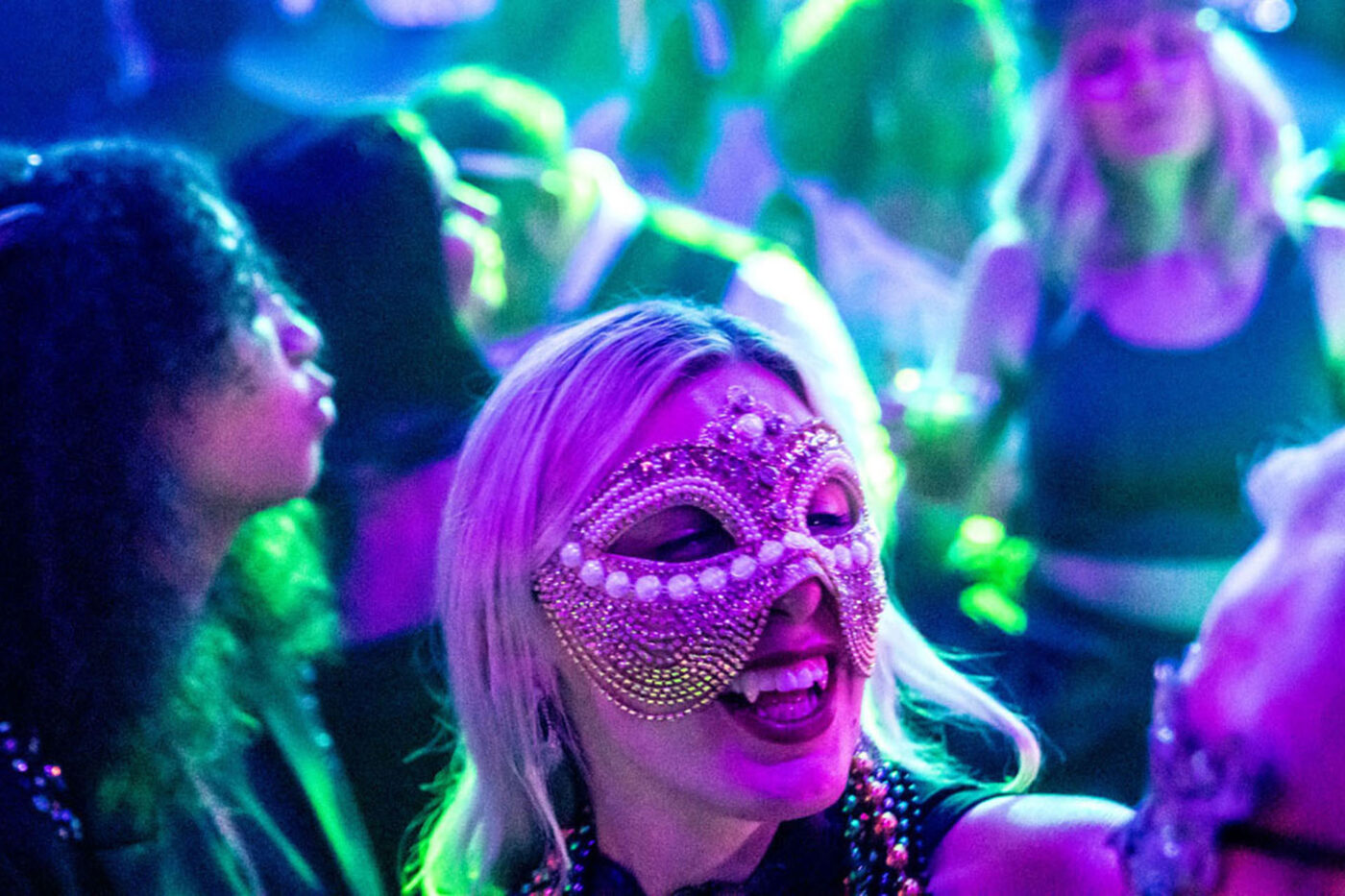 Somebody in a masquerade mask smiling and dancing