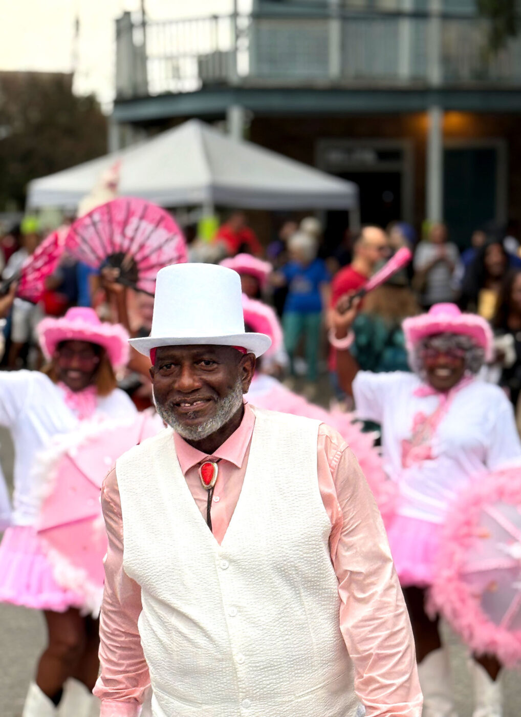 A man smiling at the camera in the middle of a parade.