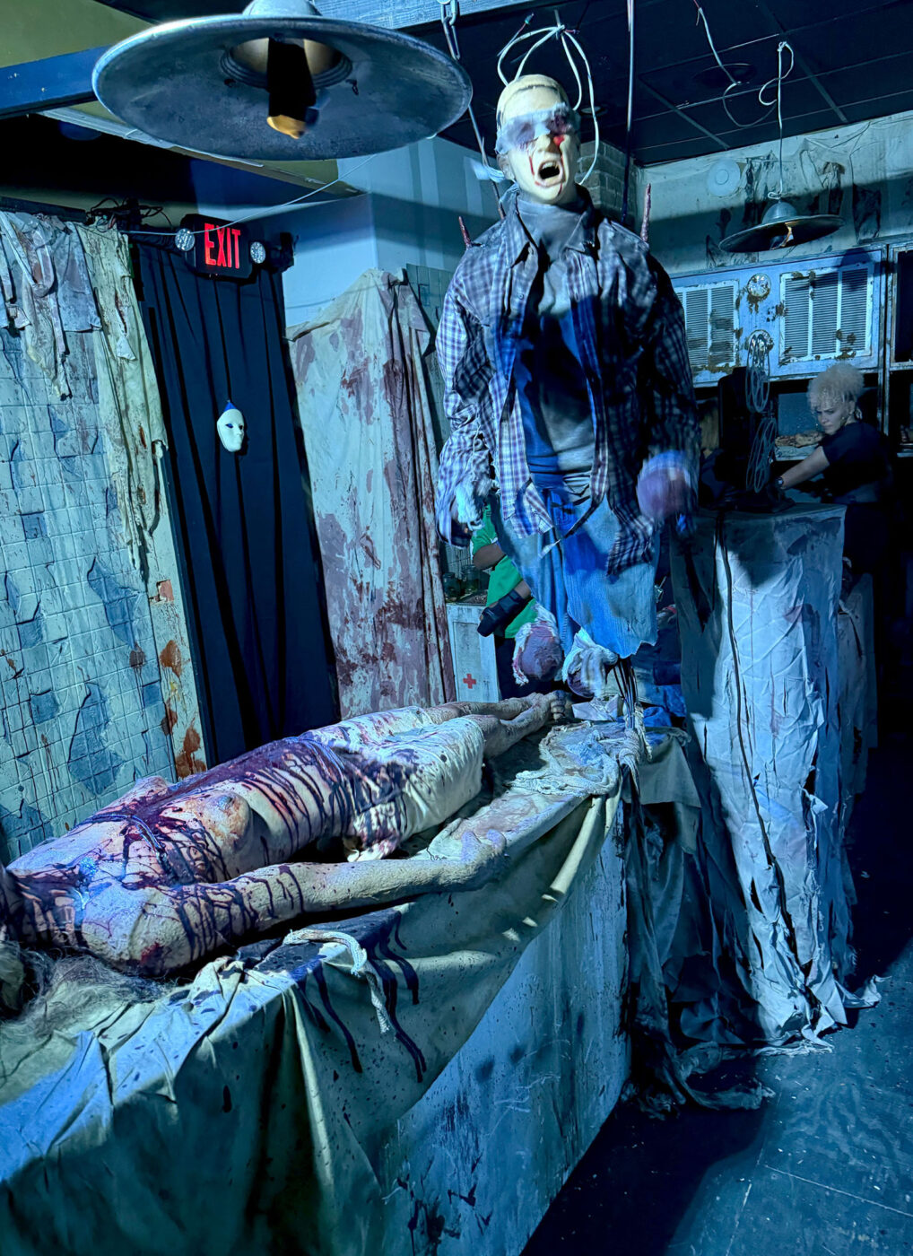Somebody dressed as a scary dead person in a dark, dingy hospital room.